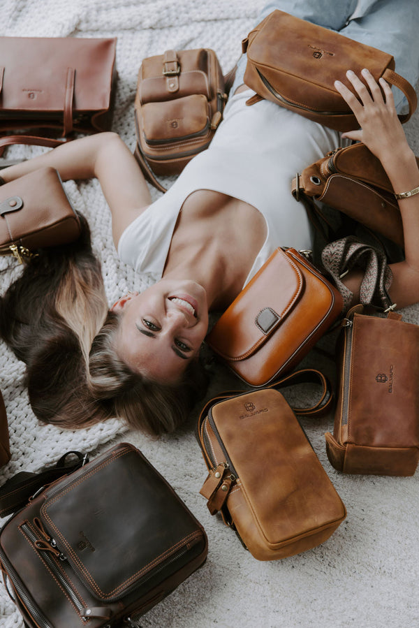 Woman lying on a blanket surrounded by Balvaro leather bags